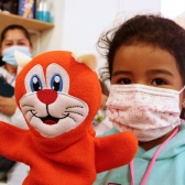 Niña en primera infancia jugando con títere