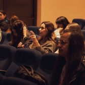 Personas sentadas en auditorio escuchando 