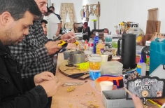 Hombres trabajando con materiales reciclados en una mesa 