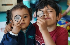 Niña y niño con lupas