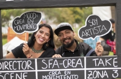 dos personas sonrien mientras sostienen un fotografama de cine gigante. Fotografía por Lina Pachón