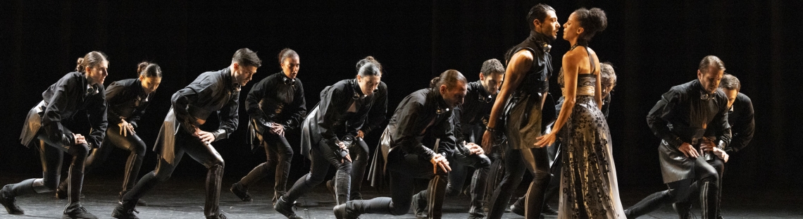 12 artistas en tarima vestidos de negro