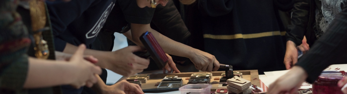 Un grupo de personas elaborando grabados sobre una mesa