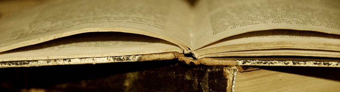Libro viejo abierto sobre dos libros más.