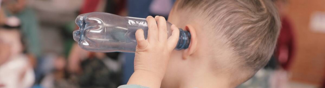 niño con botella en la oreja