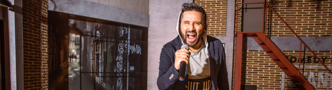 Hombre con micrófono con actitud de grito en escena