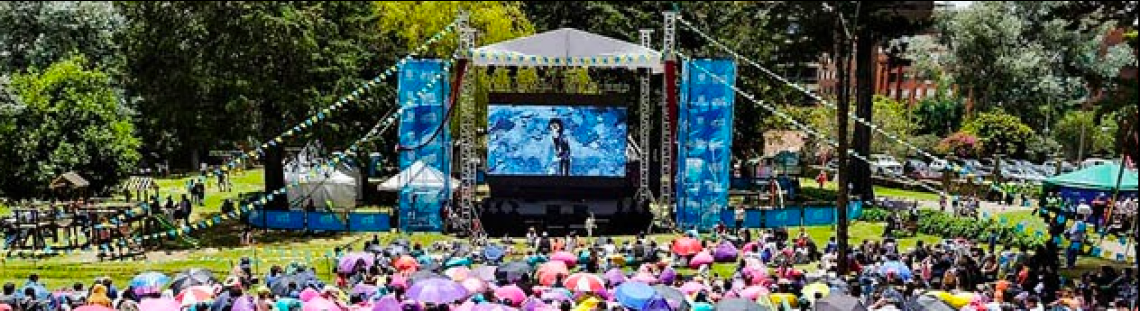 Grupo de personas sentadas en el parque viendo películas 