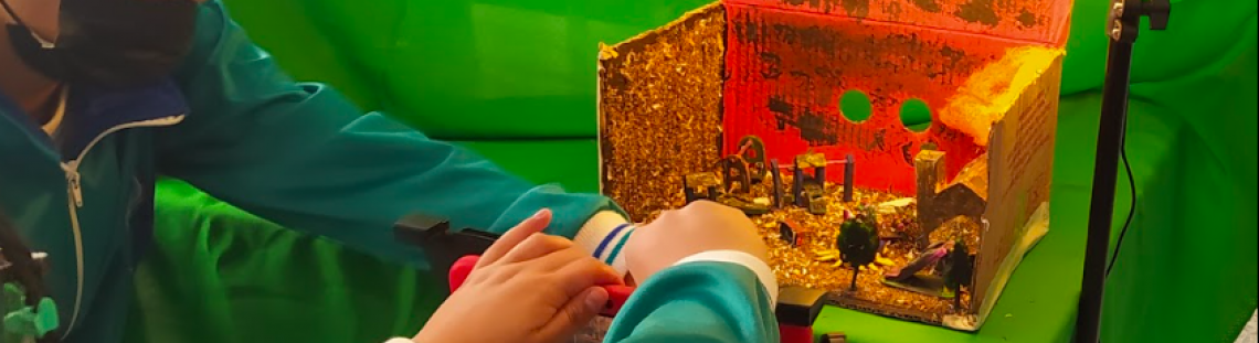 Niños organizando una maqueta con un foco de luz 