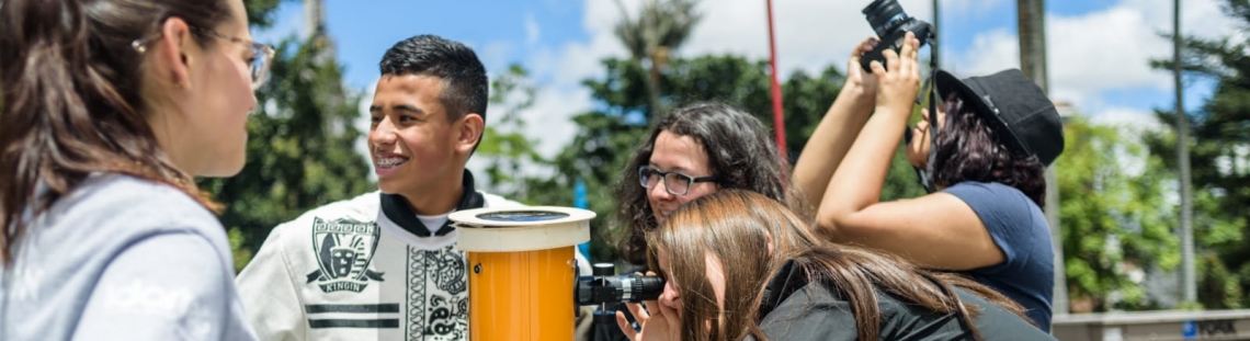 Personas al aire libre en actividad con telescopio