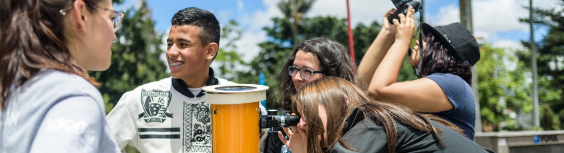 Personas mirando por un telescopio. 