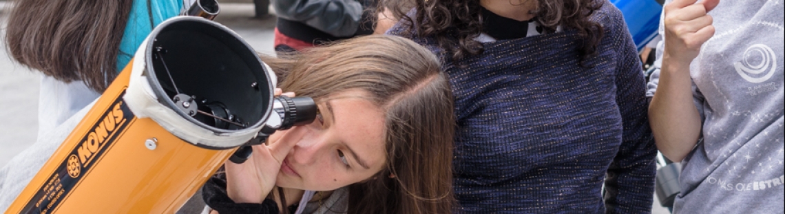 Niñas observando por telescopio. 