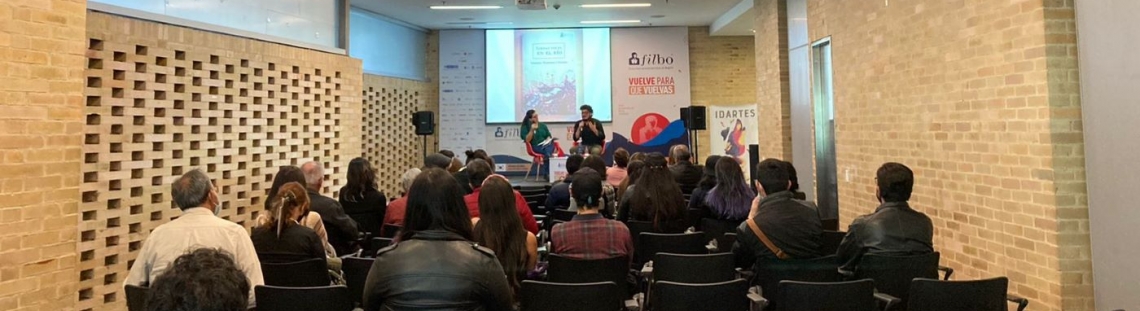 Salón con gente sentada escuchando una conferencia