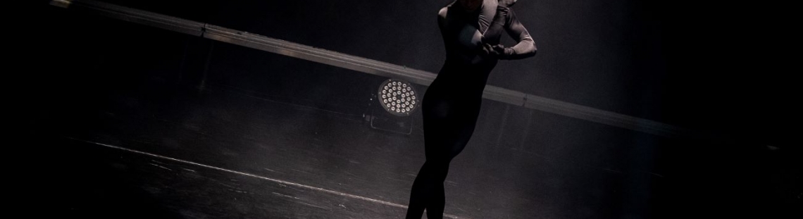 Hombre vestido de negro sobre escenario bailando ballet
