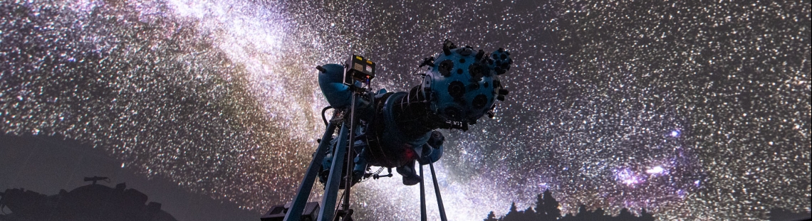 Proyector óptico mecánico en el domo con proyección del cielo de fondo. 