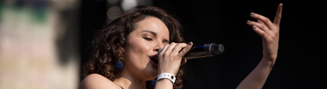 Mujer joven cantando en un concierto