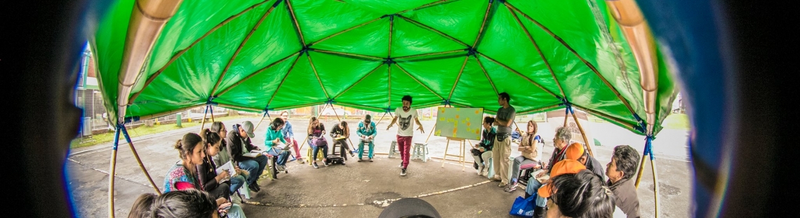 Imagen circular de niños participando en una actividad recreativa al aire libre