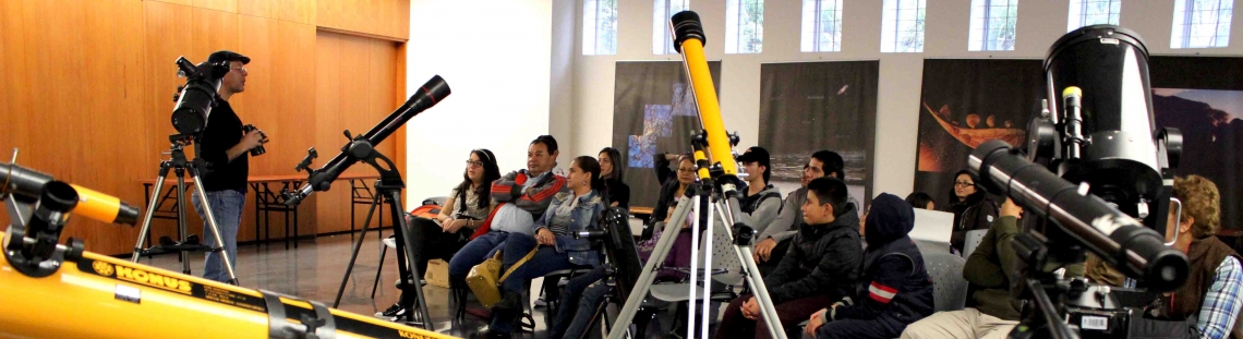 Personas en sala con telescopios