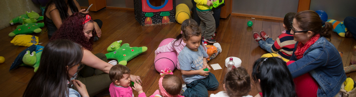 Mujeres y niños participando de una actividad lúdica e instructiva.