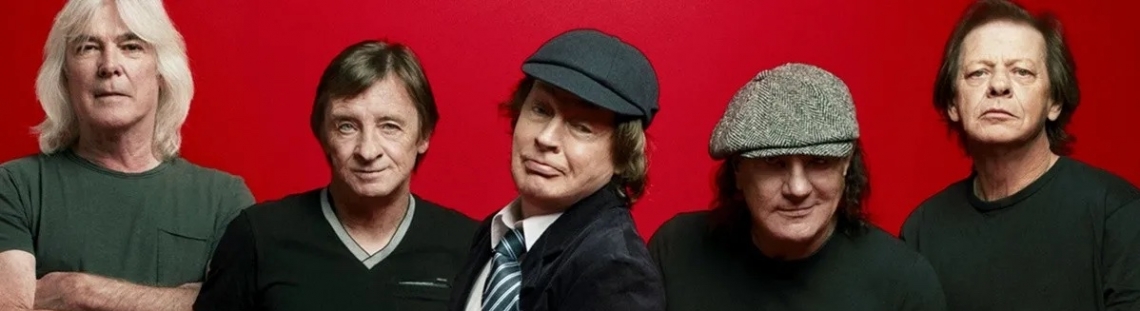 Cinco integrantes de ACDC vestidos de oscuro con fondo rojo. 