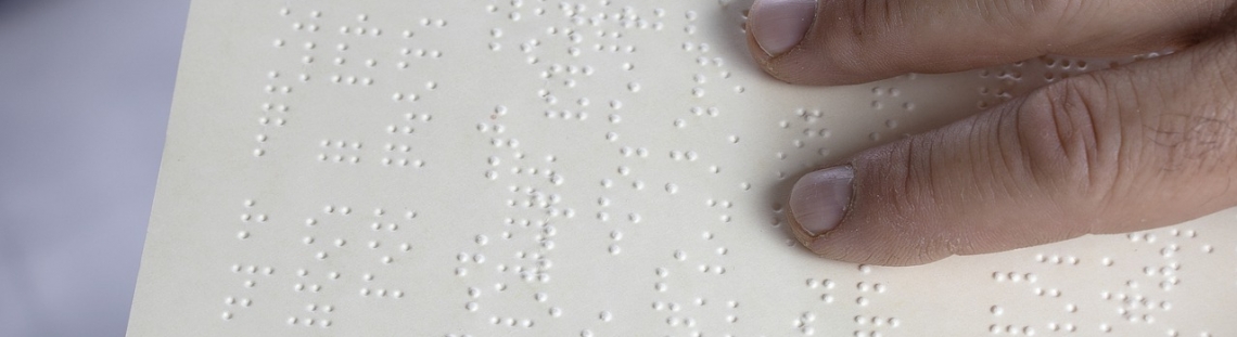 Mano sobre texto en braille. 