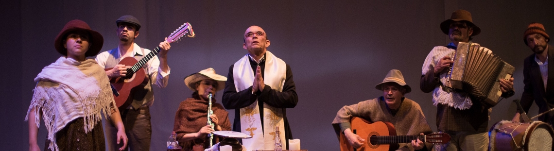 Sacerdote rezando una oración junto con campesinos que tocan instrumentos