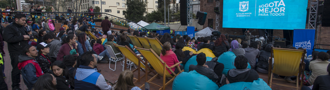 Personas al frente de una pantalla gigante al aire libre