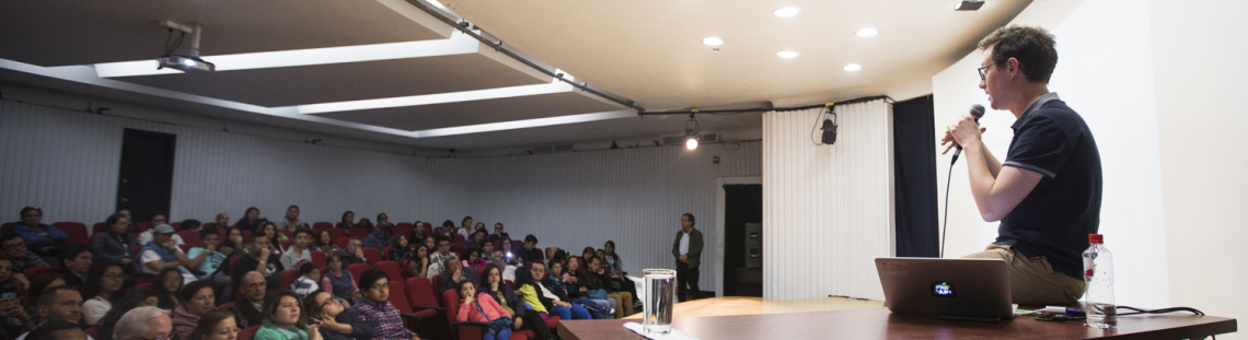 Hombre dando una conferencia en un salón con público