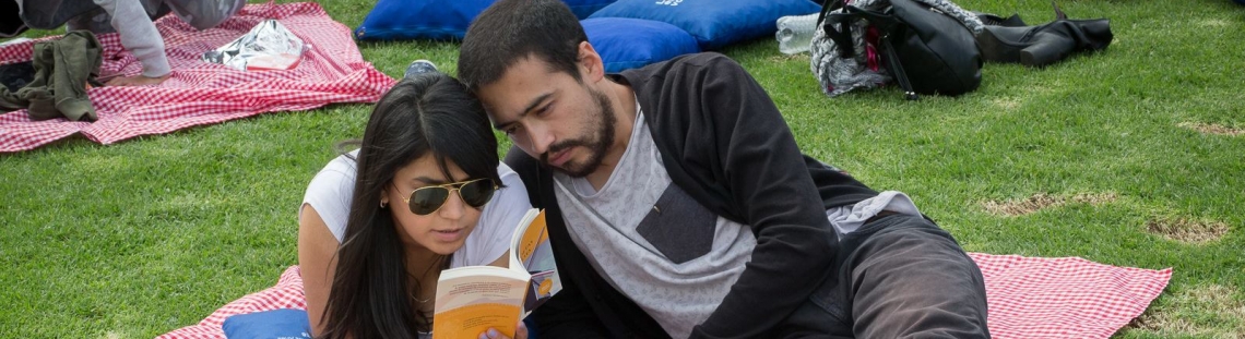 Dos personas disfrutando de la lectura al aire libre.