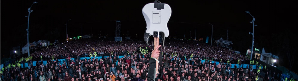 Guitarrista con instrumento en el aire frente a multitud de Rock al Parque