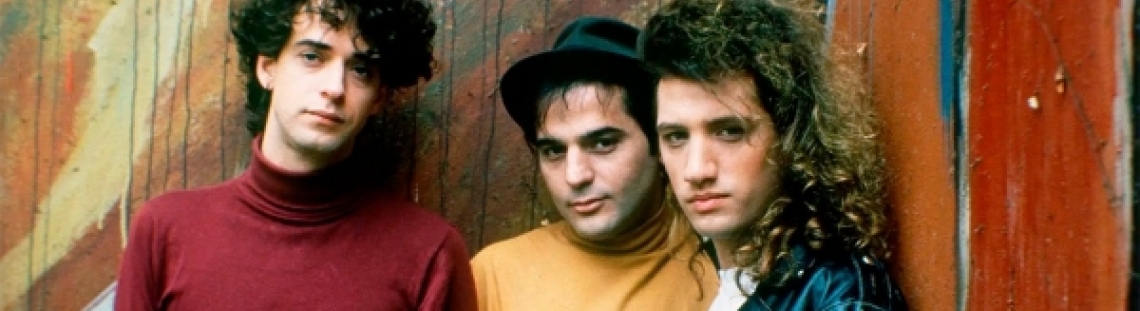 Tres integrantes de Soda Stereo enfrente de una pared. 