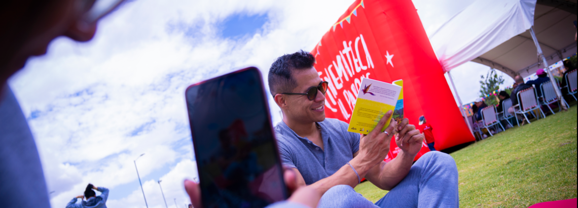 Persona sonriendo frente a un libro mientras posa para una foto. Foto: Alexis Lozano Tafur