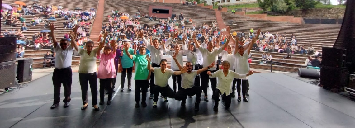 un grupo de adultos mayores en la tarima del teatro al aire libre la media torta