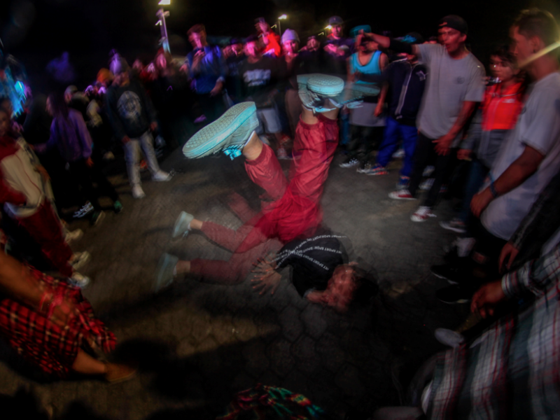 Grupo de bailarines de hip hop en un circulo danzando.