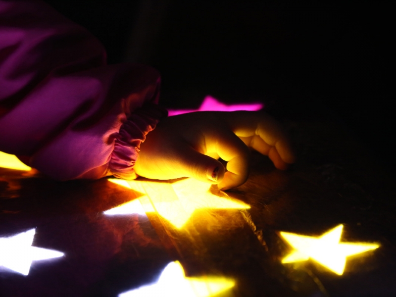 Mano de niño jugando con estrellas iluminadas