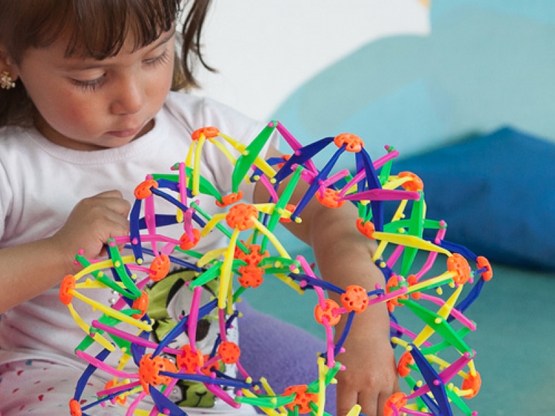 Niña jugando con estrella de colores vivos.