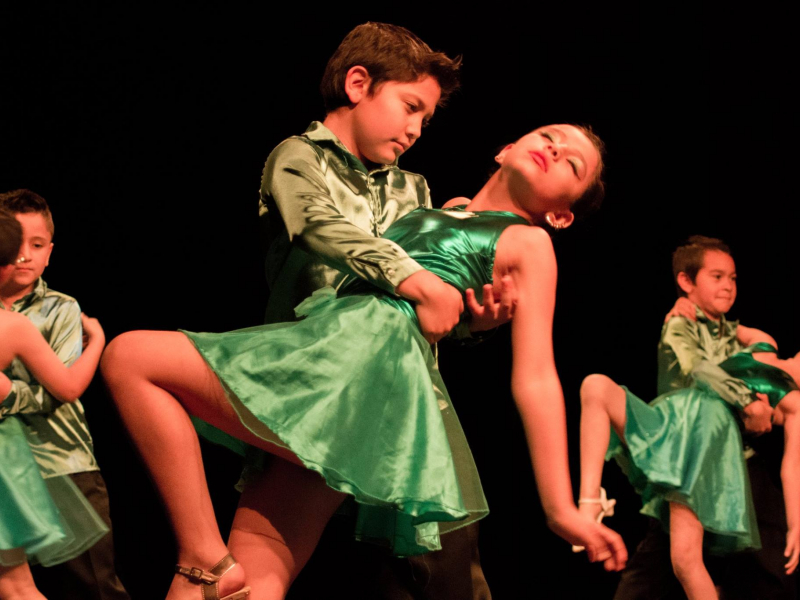 Niños bailando con trajes verdes