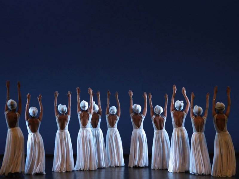 Bailarinas con trajes blancos de falda larga y sombrero danzando.