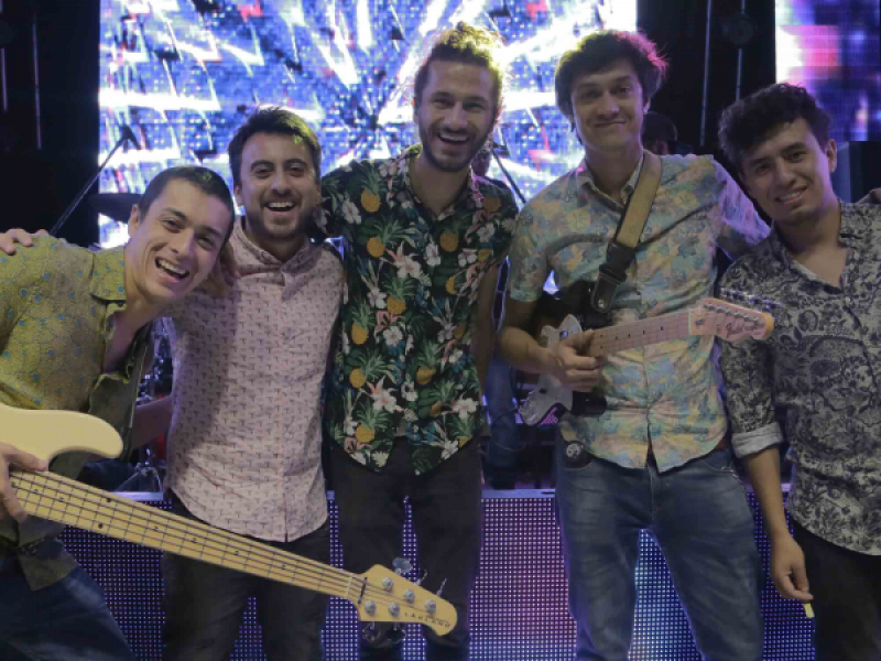 Hombres frente a una pantalla posando para la cámara