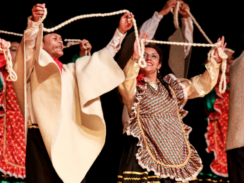 Bailarines con trajes típicos y ruanas en escena