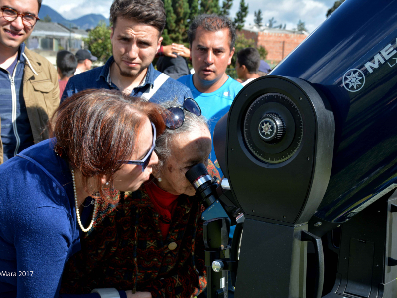 Personas observando a través del telescopio