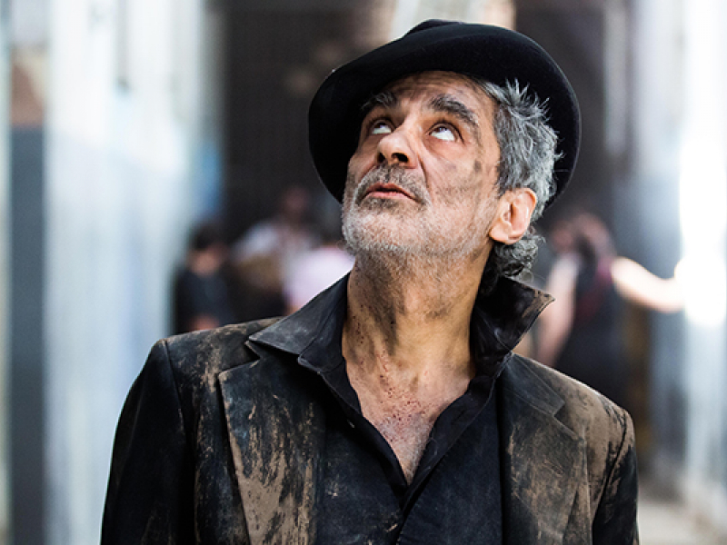 Imagen de Daniel Melingo de medio plano con sombrero mirando al cielo.