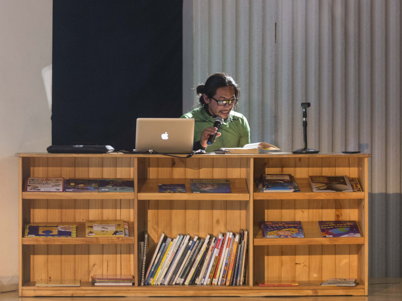 Hombre en una bibliotreca leyendo para el público