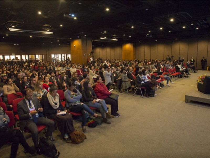 Personas participamdo de una conferencia en un salón de la Biblioteca Luis Ángel Arango