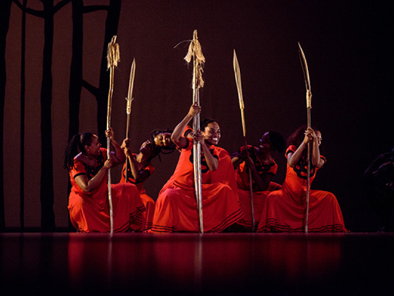 Mujeres bailando en el escenario vestidas de rojo