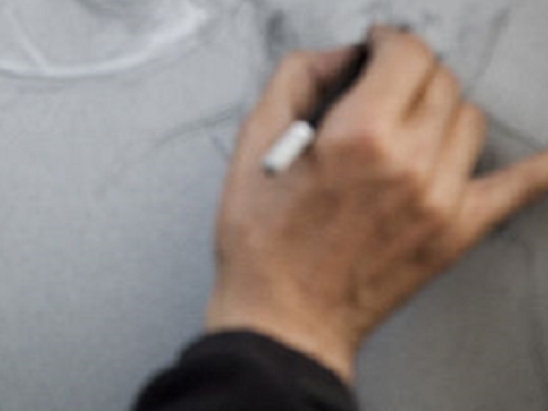 Mano dibujando sobre papel blanco