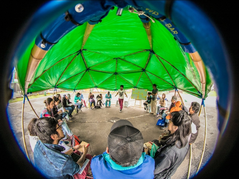 Imagen circular de niños participando en una actividad recreativa al aire libre