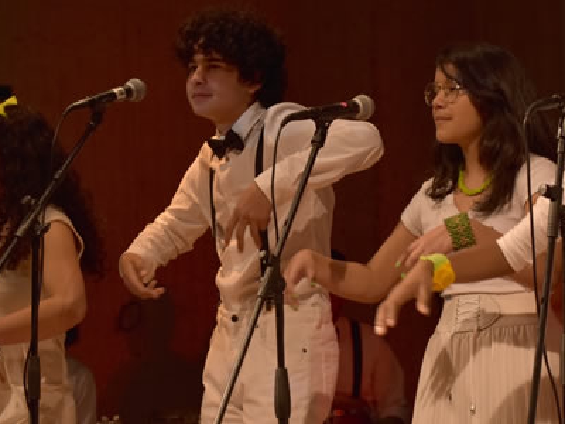 Grupo de jóvenes en escena vestidos de blanco