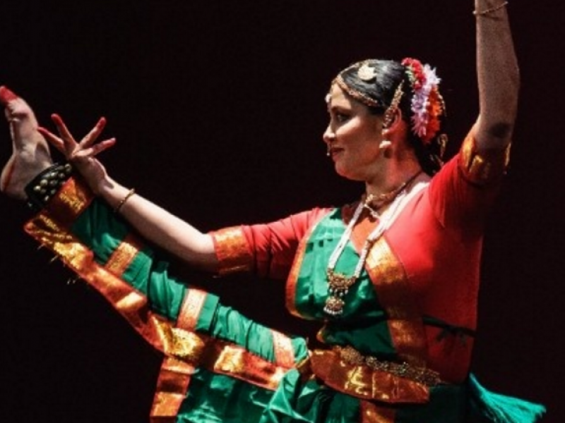 Mujer danzando con vestido colorids y alegre