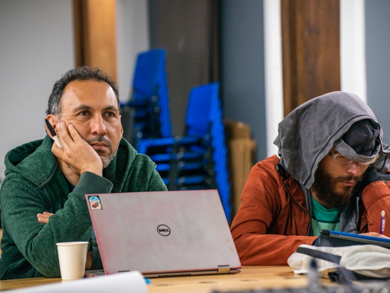 Personas atendiendo clase con computador