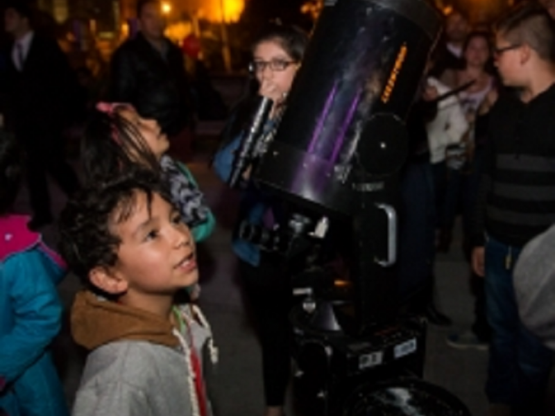 Personas participando de un ejercicio de observación nocturna con telescopio